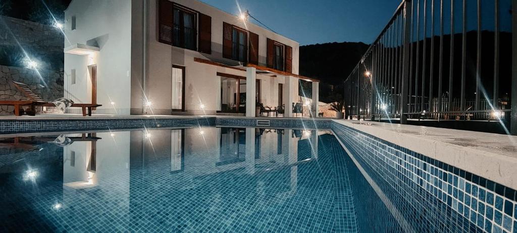 - une piscine en face d'un bâtiment la nuit dans l'établissement Villa Ivka, à Ploče