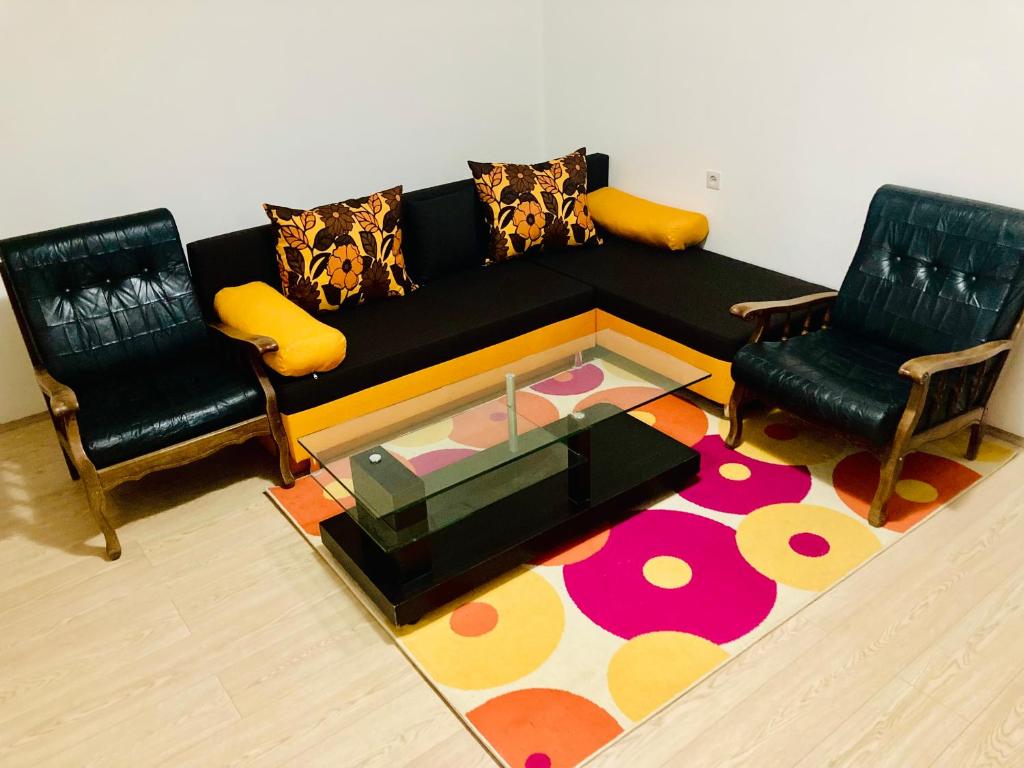 sala de estar con sofá negro y 2 sillas en Alexia, en Skopje