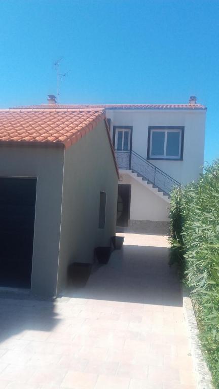 une maison blanche avec un escalier en face de celle-ci dans l'établissement Appartement 6-8 personnes- 3 chambres- proche de tout à pied, à La Chaume