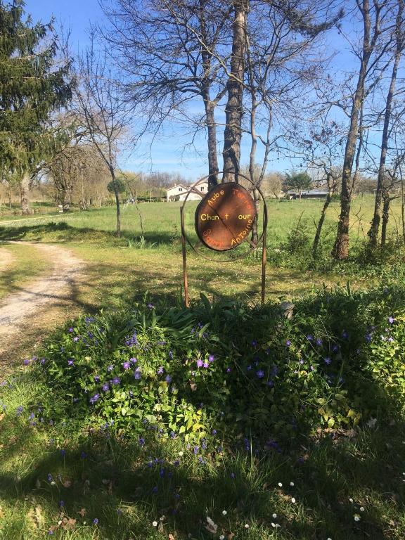 a sign in the middle of a field with flowers at Maison d hôtes Les Chantours dans réserve naturelle 15 hectares in Saint-Antoine-Cumond
