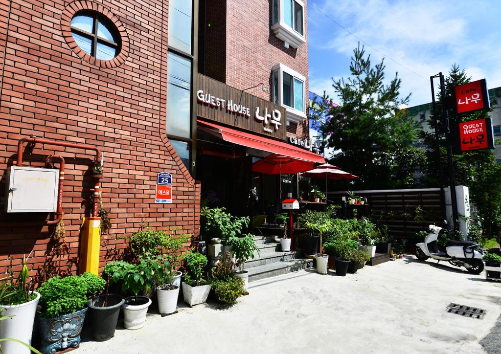 慶州市にあるキョンジュ ナム ゲストハウスのレンガ造りの建物の前にある鉢植えのカフェ