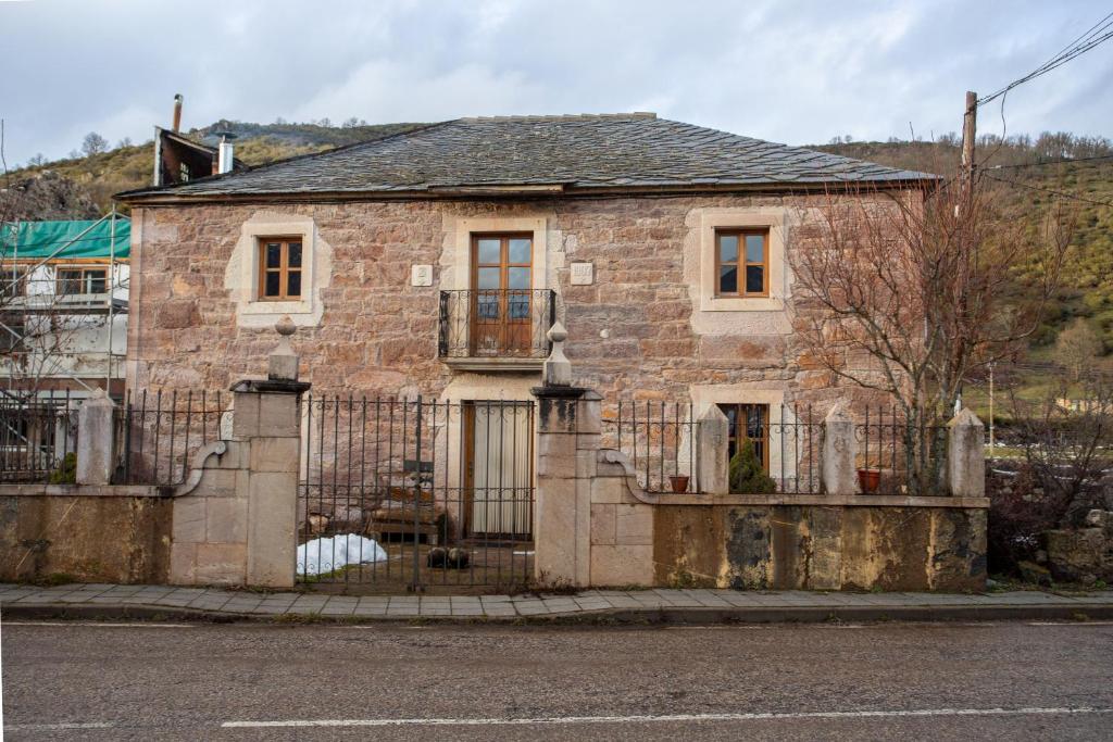 an old stone house with a wrought iron fence at Casa Rural Anita in Cabrillanes