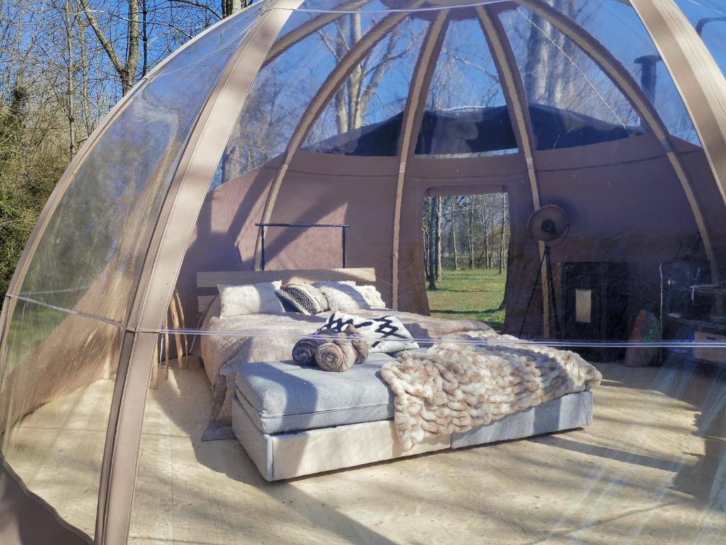 a room with a bed in a dome shaped tent at OUT & LODGE, Wigwam in Couvin