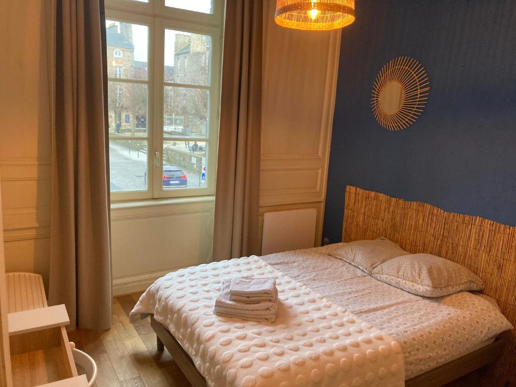 um quarto com uma cama com toalhas em L'Aparthé Dinan - Vue sur la place du marché em Dinan