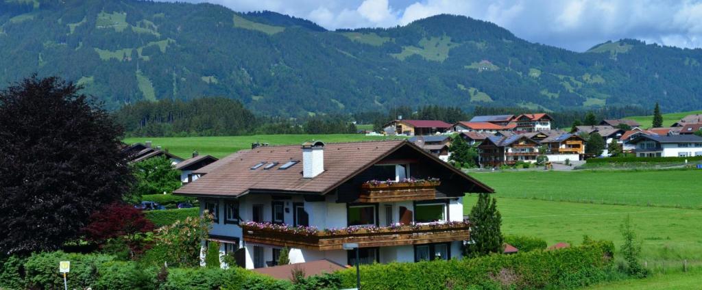een huis in een dorp met bergen op de achtergrond bij Panoramablick Ferienwohnungen in Fischen