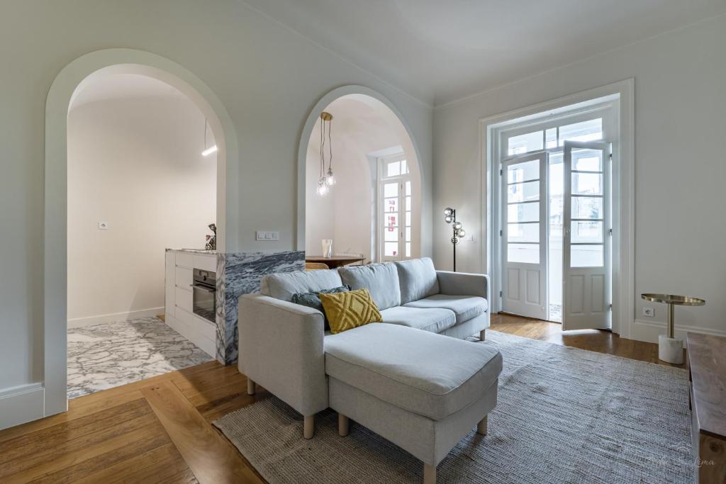 een woonkamer met een bank en een stoel bij Nomad's Family - 3BDR Charming Hideout Porto in Porto