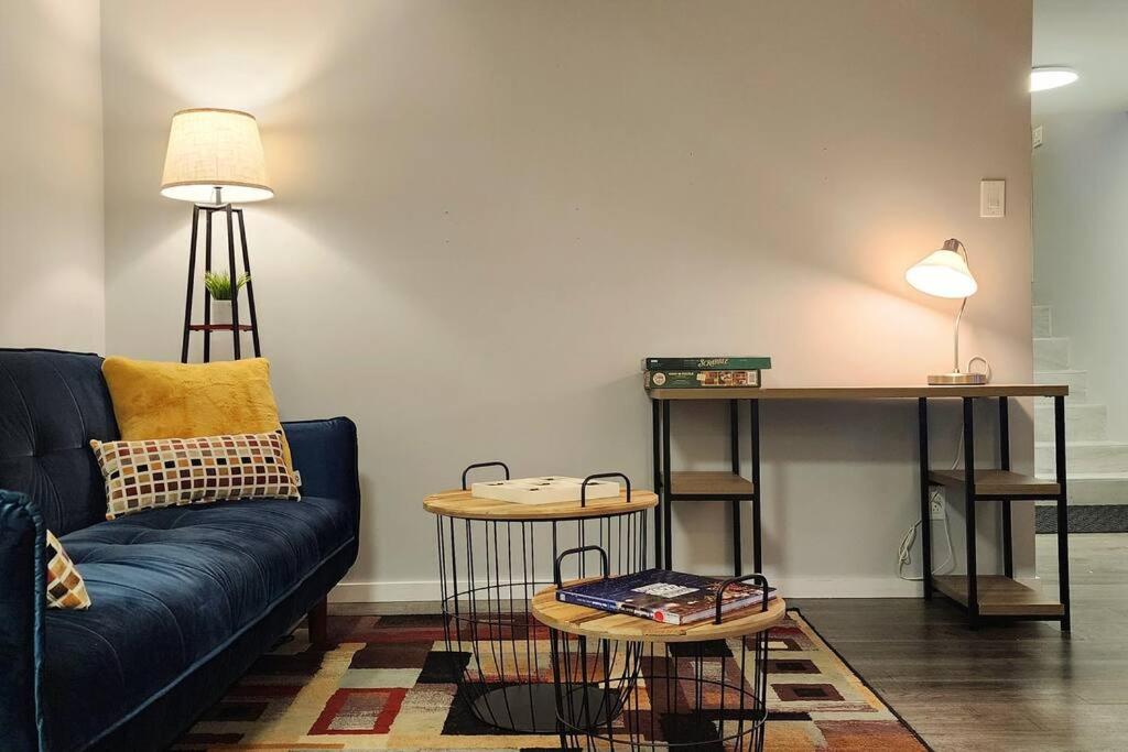 ein Wohnzimmer mit einem blauen Sofa und einem Tisch in der Unterkunft Guest Suite in Saint Hubert, bus to REM and Metro in Longueuil