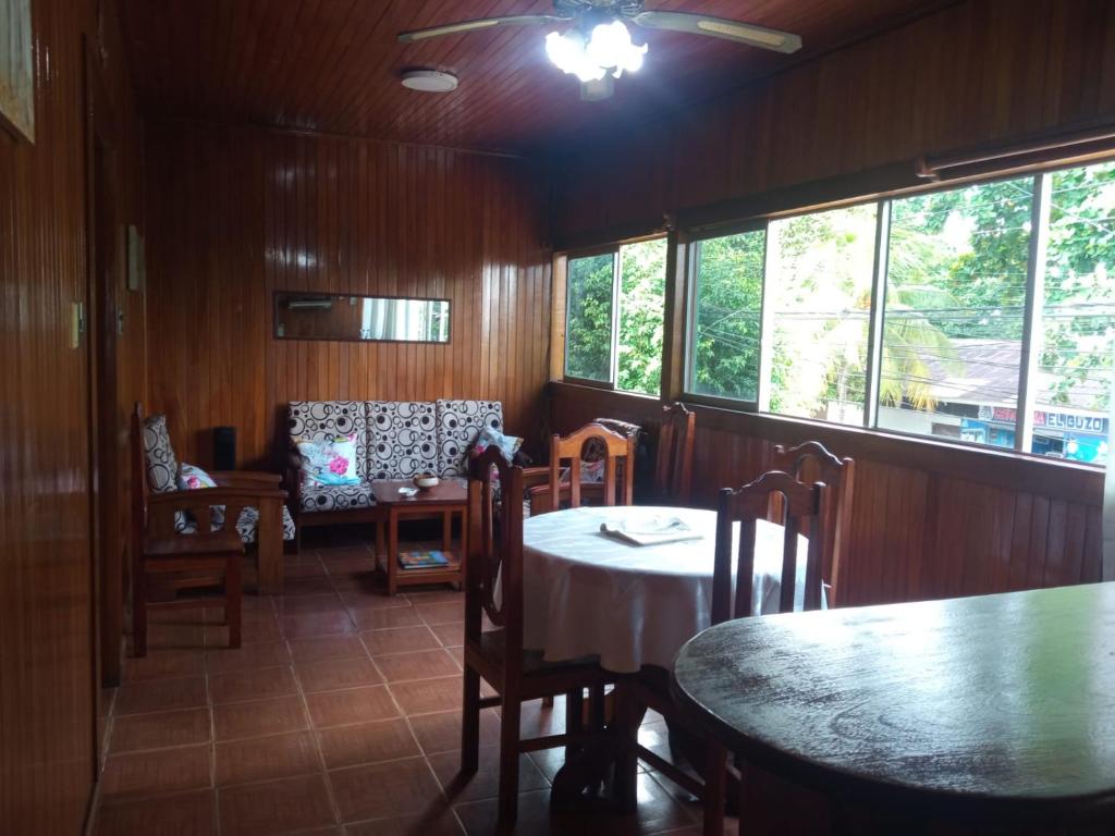 a dining room with a table and chairs and windows at DouchkaHouse in Puerto Maldonado