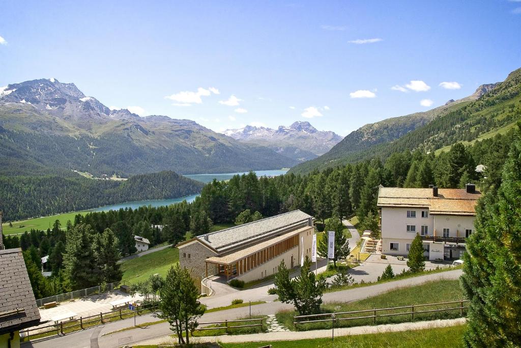 - un bâtiment avec vue sur le lac et les montagnes dans l'établissement Berghotel Randolins, à Saint-Moritz