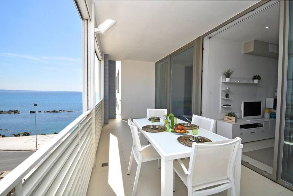 uma sala de jantar branca com vista para o oceano em Suite Gallipoli con vista mare da 4 posti e wifi em Gallipoli