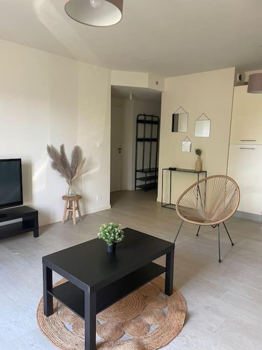 - un salon avec une table basse noire et une chaise dans l'établissement Appartement 60m2 RDC, à Vannes