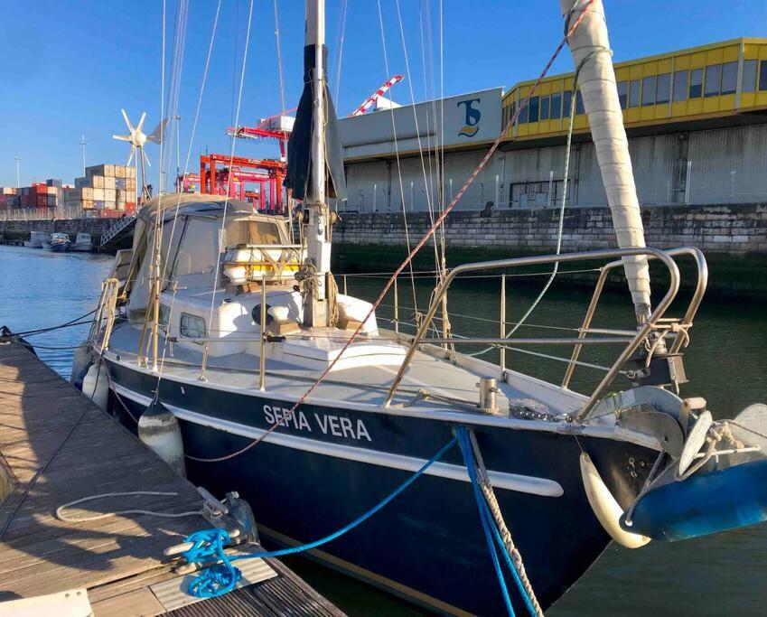 a blue boat is docked at a dock at Cozy Lisbon Marina Sleepaboard - Sail Away in Lisbon