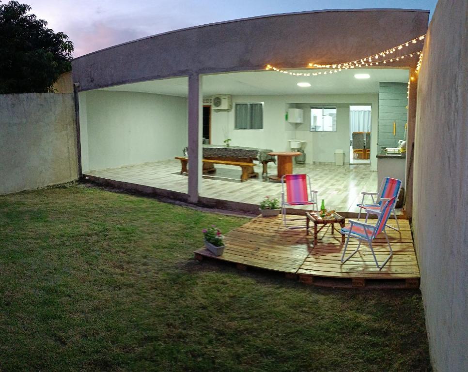 um deque com duas cadeiras e uma mesa num quintal em Casa aconchego da Camila em Foz do Iguaçu