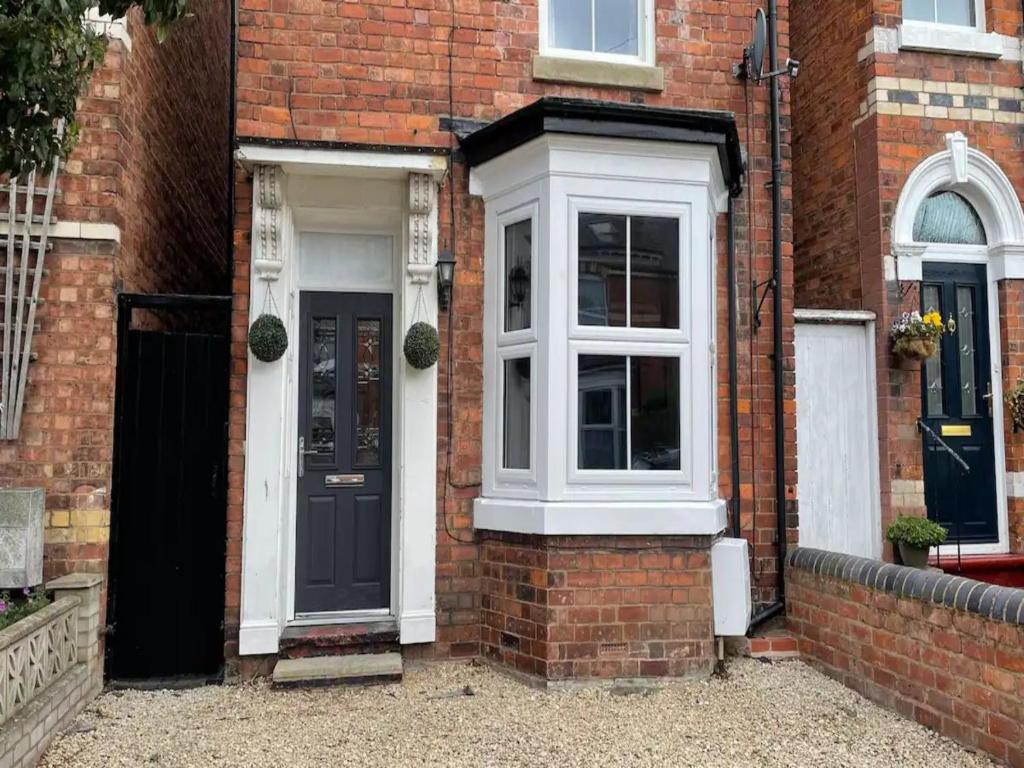a brick house with a black door and a white window at Pass the Keys Two bedroom Victoria Town house, easy walk of town in Shrewsbury