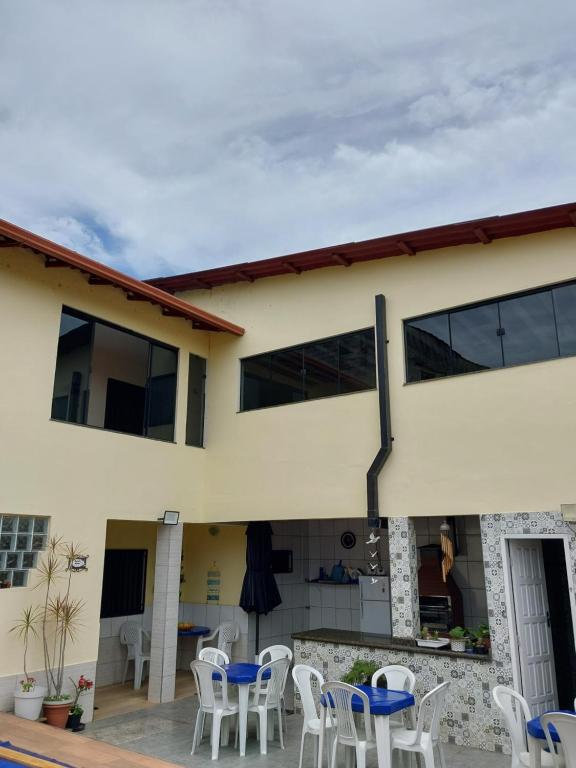 a house with white chairs and a patio at Casa com Piscina in Serra