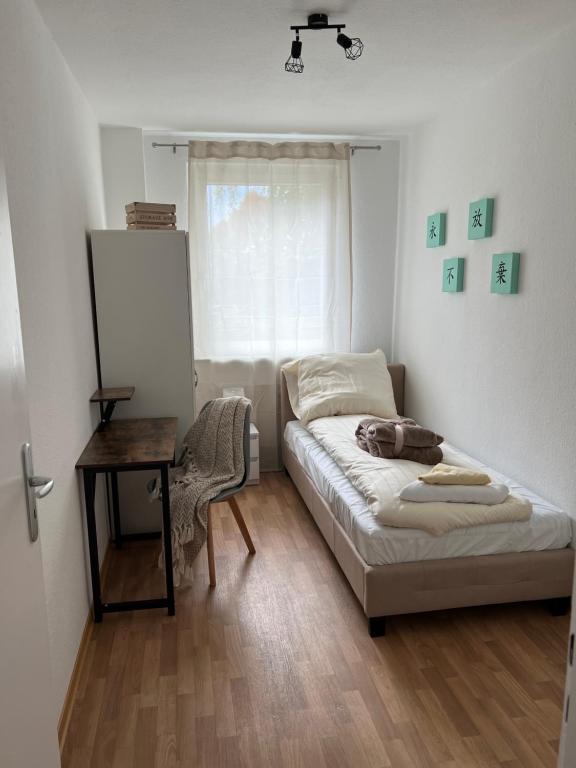 a bedroom with a bed and a table and a window at Unterkunft für bis zu 5 Personen in Spremberg in Spremberg