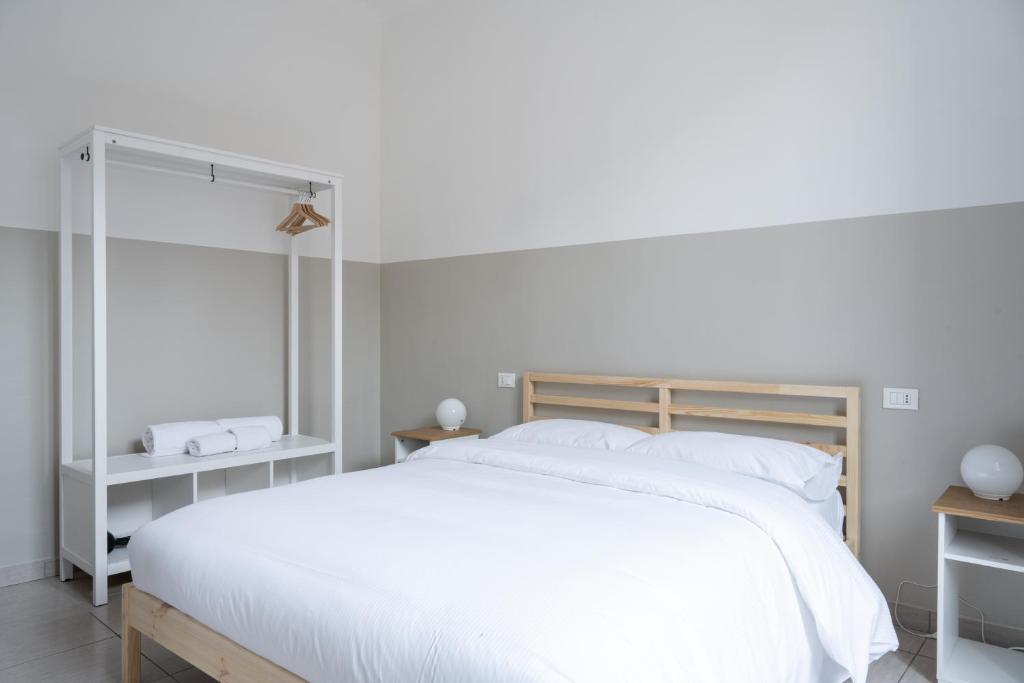 ein Schlafzimmer mit einem großen weißen Bett mit weißen Kissen in der Unterkunft Duomo Apartment in Florenz