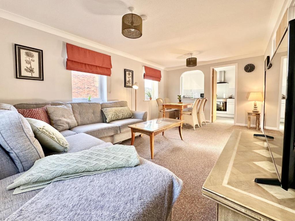ein Wohnzimmer mit einem Sofa und einem Tisch in der Unterkunft Fewster Apartment - City Centre location with free parking in York