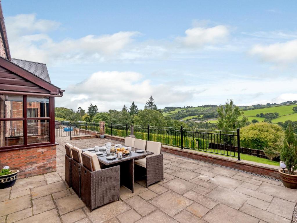 a patio with a table and chairs and a balcony at 3 bed in Builth Wells 78329 in Crickadarn