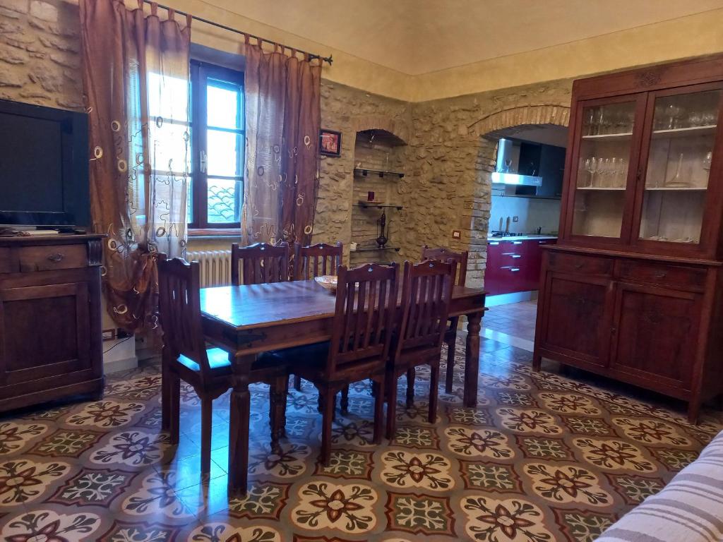 een eetkamer met een houten tafel en stoelen bij Casa Marzocco in Pomarance