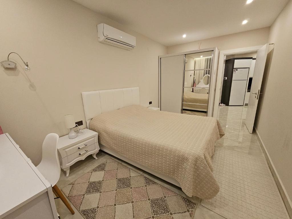 Habitación blanca con cama y espejo en Konak Tower, en Alanya