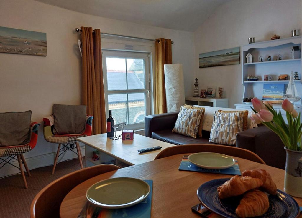 uma sala de estar com um sofá e uma mesa em Salt Marsh Apartment em Tywyn