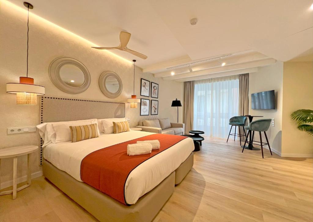 a bedroom with a large bed and a living room at Apartamentos Soho Boutique Palillero in Cádiz