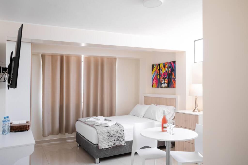 biała sypialnia z łóżkiem i stołem w obiekcie Residencial Suiza w mieście Lima
