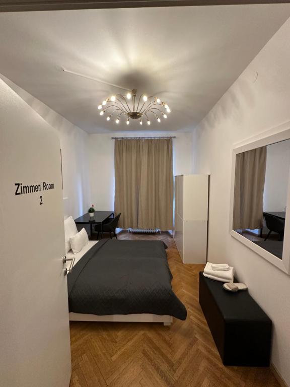 sypialnia z dużym łóżkiem i żyrandolem w obiekcie DATRI Petite Suite 1 - 3 w Wiedniu