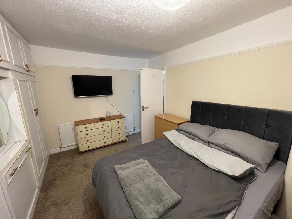 a bedroom with a bed and a flat screen tv at Private Luxury Rooms RM2 in Northenden