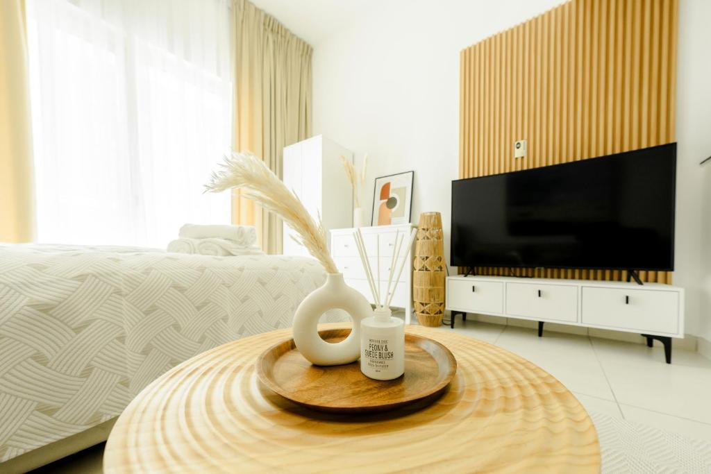 a bedroom with a table with a vase and a tv at Chic Apartment Dubai Marina in Dubai