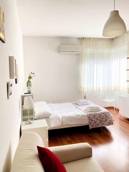 a bedroom with two beds and a couch in it at MHOME APARTMENT - Roma in Rome