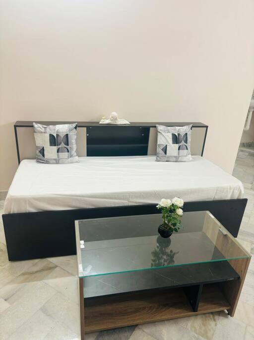 a bed with a glass table with a vase of flowers at Simhagiri Sea Holiday Inn in Visakhapatnam