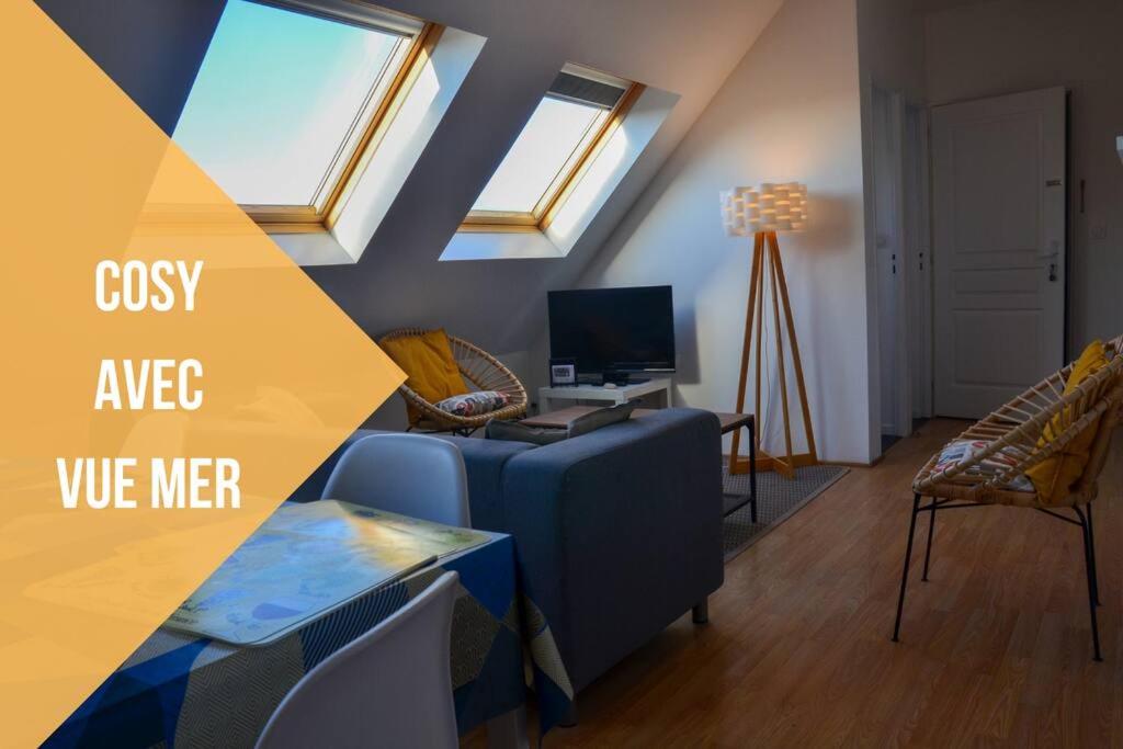 - un salon avec un canapé, une table et des fenêtres dans l'établissement Camelia; Beau logement lumineux, avec vue sur mer, à Wimereux