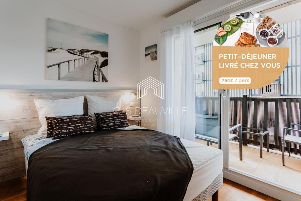 um quarto com uma cama e uma placa num quarto em 1 Mirabeau C.L.S Deauville em Deauville