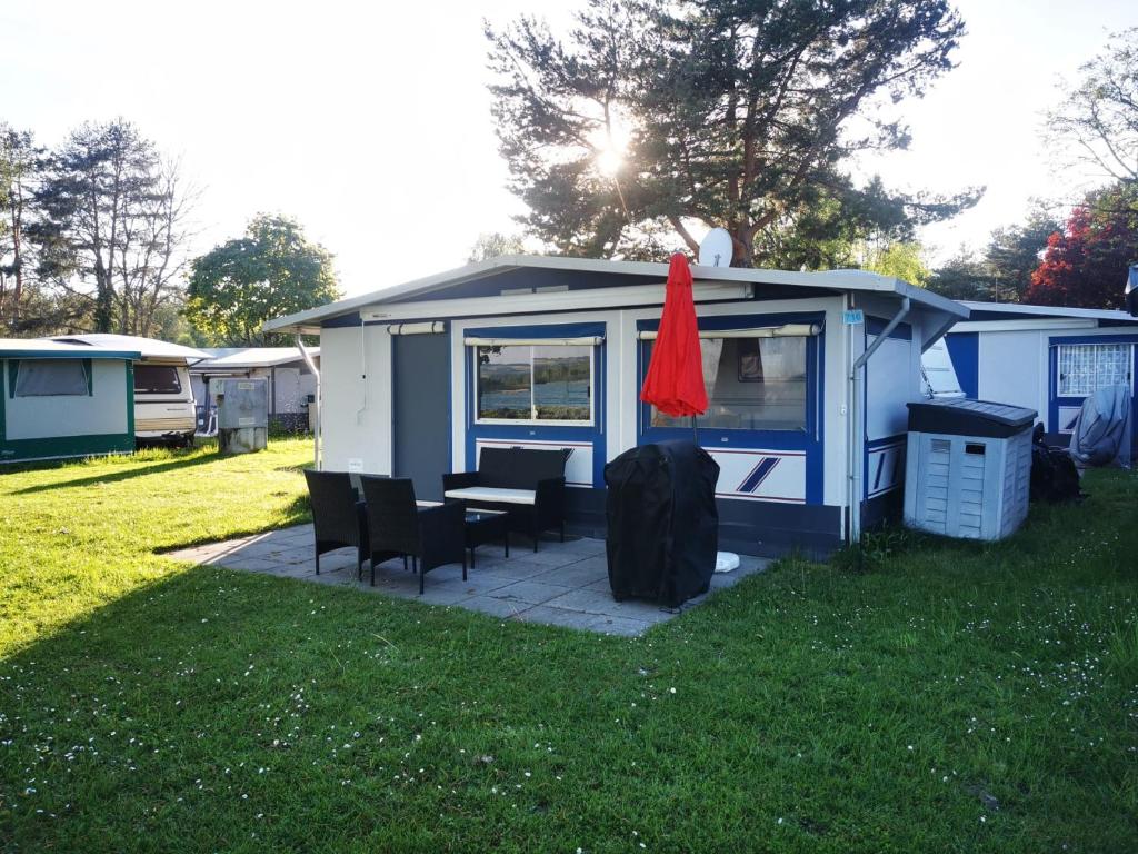 a tiny house with a table and chairs in the grass at La Bordu in Grandson