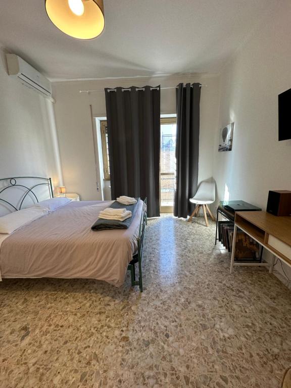 1 dormitorio con cama, escritorio y ventana en Eufonia Gemelli Apartment, en Roma