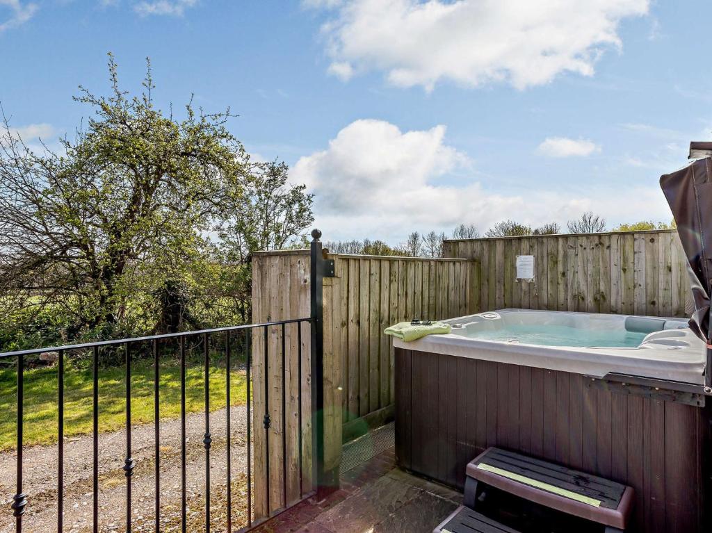 a jacuzzi tub in a wooden fence at 4 Bed in Taunton KIBTR in Trull