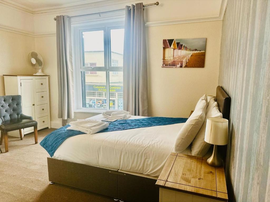 a bedroom with a large bed and a window at The Wash & Tope in Hunstanton