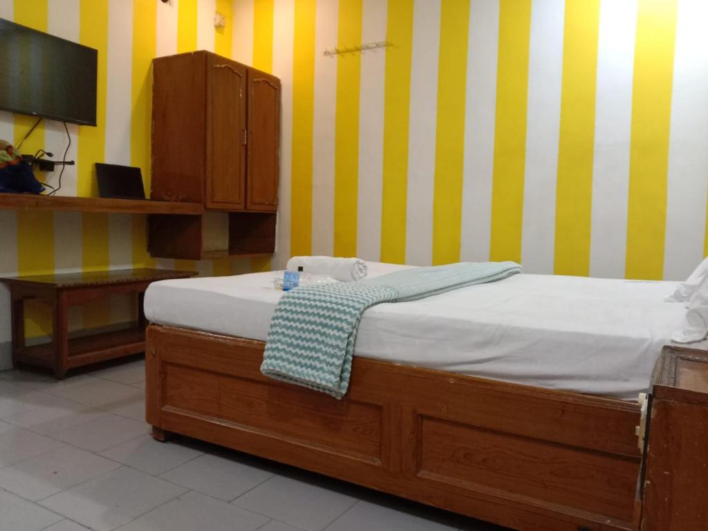 um quarto com uma cama, um armário e uma televisão em HOTEL SOWMYA INN em Ongole