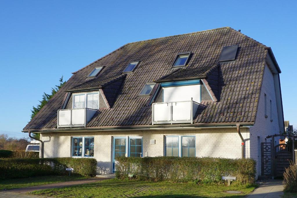 una casa con techo de tejas y ventanas en Ferienwohnung Ostseebrise, Schönberger Strand en Schönberger Strand