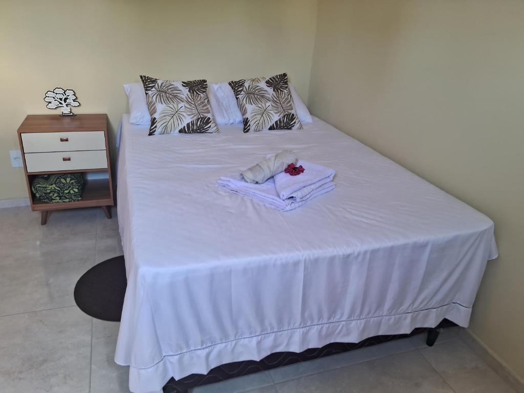 a white bed with a towel on top of it at Casa vila costeira. in Camocim
