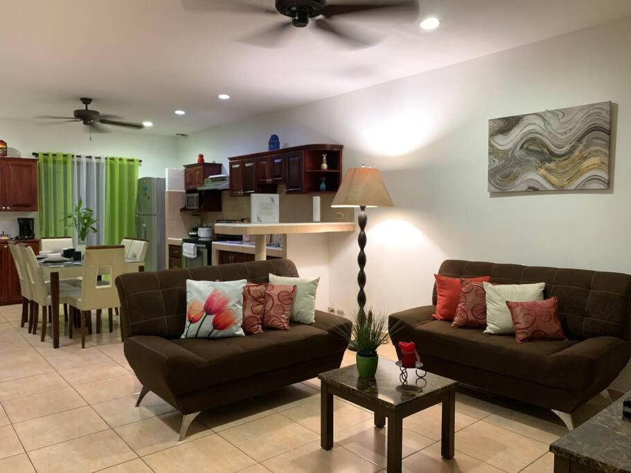 sala de estar con 2 sofás y comedor en Casa Suiza – Schweizer Haus, en Liberia