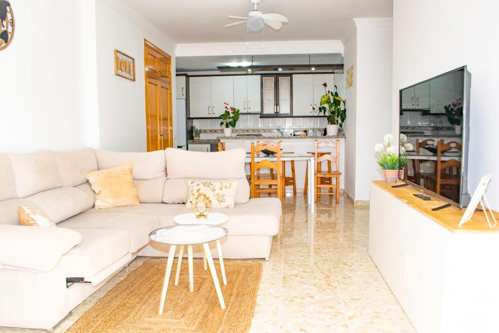a living room with a white couch and a kitchen at Casa playa Melosas- Torre del mar- HOME RENT MALAGA in Torre del Mar