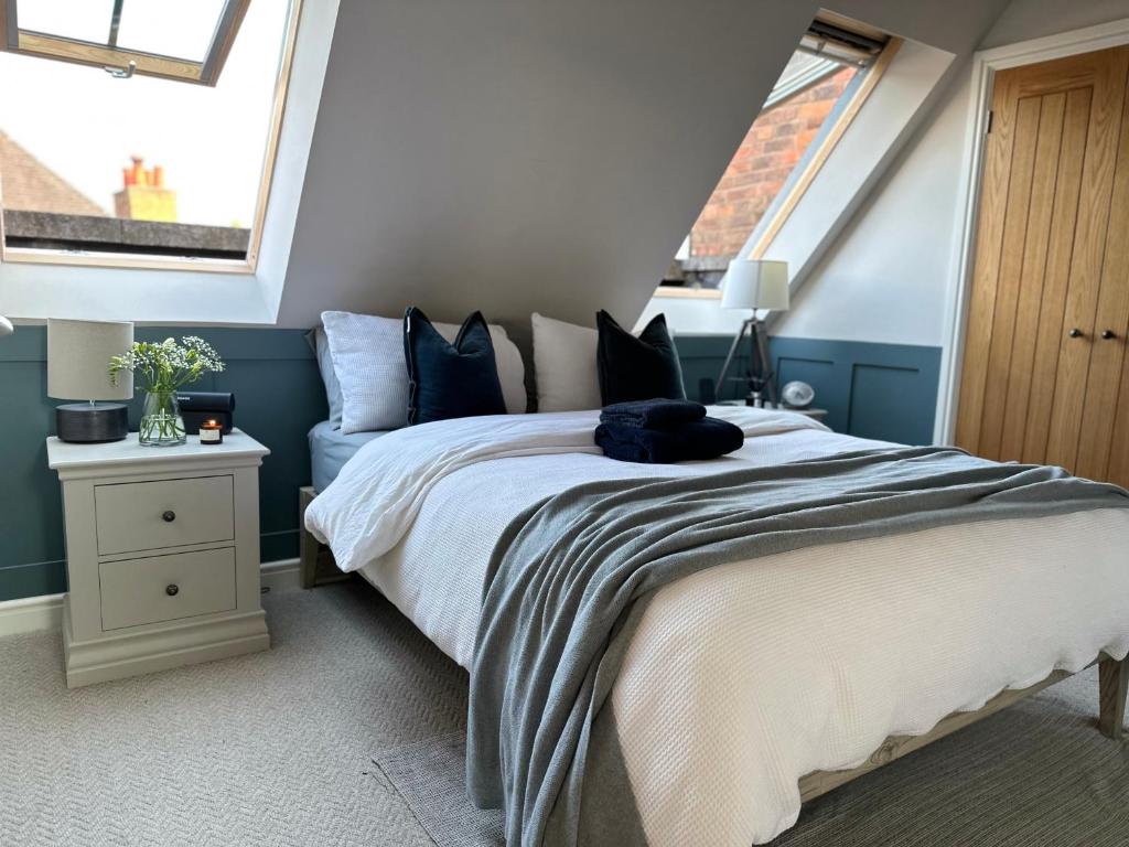 ein Schlafzimmer mit einem Bett und zwei Fenstern in der Unterkunft Central Warwick, Free Parking and Roof Terrace in Warwick