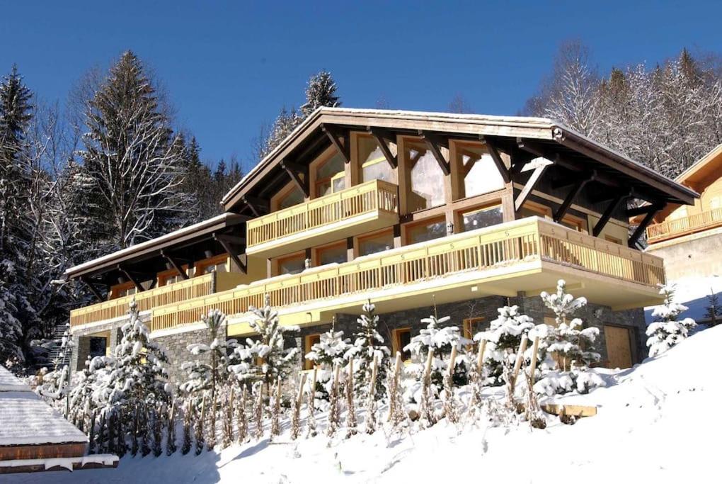 un grand bâtiment avec de la neige devant lui dans l'établissement Chalet Serena - luxury 7 Bedroom Chalet, Pool & Spa from The Hideaway, aux Houches