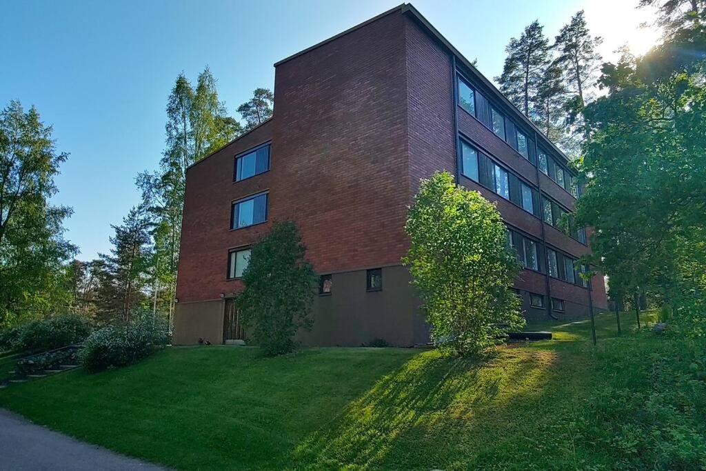 a large brick building with a grass yard in front of it at Huoneisto 1 - 4 hengelle in Strömfors