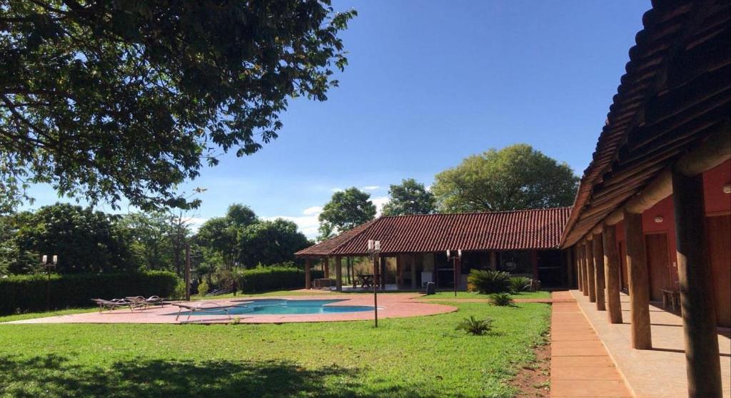 a building with a swimming pool in a yard at Pousada Aquatur in Presidente Epitácio