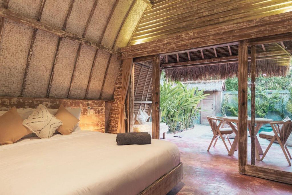 Schlafzimmer mit einem Bett und einem Tisch in der Unterkunft Villa Palma Gili Meno - Private Pool in Gili Meno