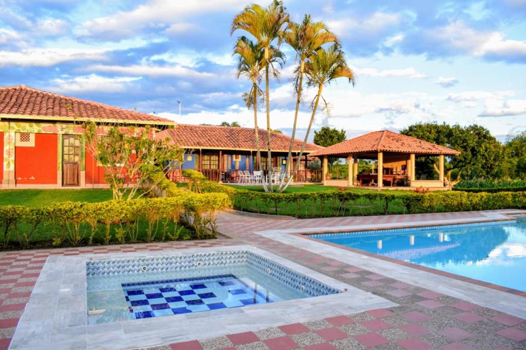 een huis met een zwembad en een resort bij hotel villa nazareth in Quimbaya